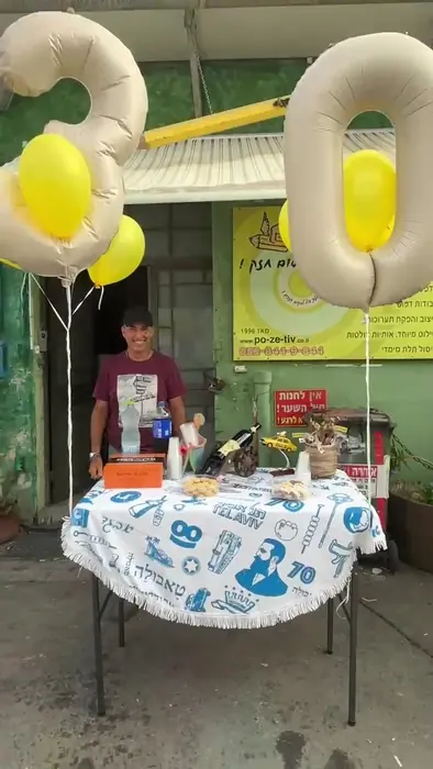 חנן אמנו בחזית סדנת פה זה טיב מתחת לבלוני השלושים, אשקלון